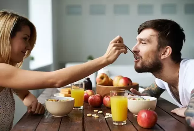 en kvinna matar en man med nötter för att öka styrkan